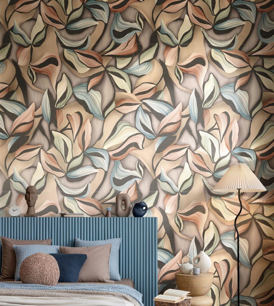 La collezione ART propone il rivestimento ceramico Decors Cirqus nel formato 60x120 cm, qui posato a tutta parete in una raffinata camera da letto. Il decoro si distingue per un elegante motivo di foglie stilizzate nei toni caldi del beige, terracotta, verde salvia e sfumature azzurre. L'ambientazione contemporanea e accogliente mostra la parete decorata dietro a una testiera del letto scanalata color carta da zucchero, arricchita da cuscini decorativi, piccoli oggetti d'arte e una lampada da terra con paralume plissettato che crea un'atmosfera intima e rilassante.