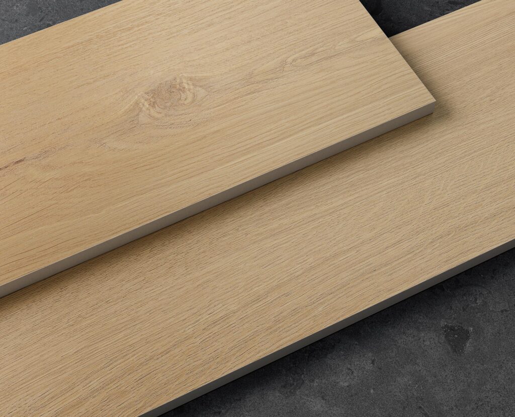 Collezione Barrique: vista ravvicinata per una comparazione tra doghe in gres porcellanato effetto legno nelle finiture Selected e Natural. Le piastrelle, caratterizzate da venature calde e dettagliati nodi tipici del legno naturale, sono presentate in una posa sovrapposta in diagonale su uno sfondo materico scuro, evidenziando lo spessore e la raffinata texture della ceramica.