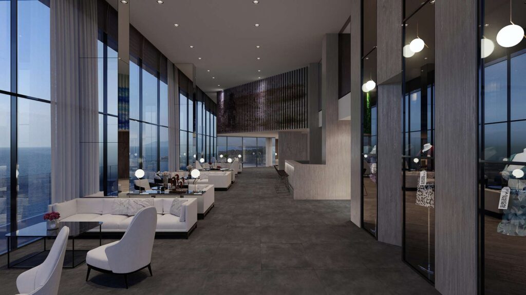 La collezione Unika, nella variante cromatica Carbon in formato 60x60 cm, definisce il pavimento di una lussuosa e spaziosa hall d'hotel dal design contemporaneo. Le piastrelle in gres porcellanato scuro sono posate in modo ortogonale, conferendo continuità visiva a un ambiente caratterizzato da imponenti vetrate panoramiche con vista mare al crepuscolo, eleganti salotti con divani bianchi e un'illuminazione calda e raffinata.