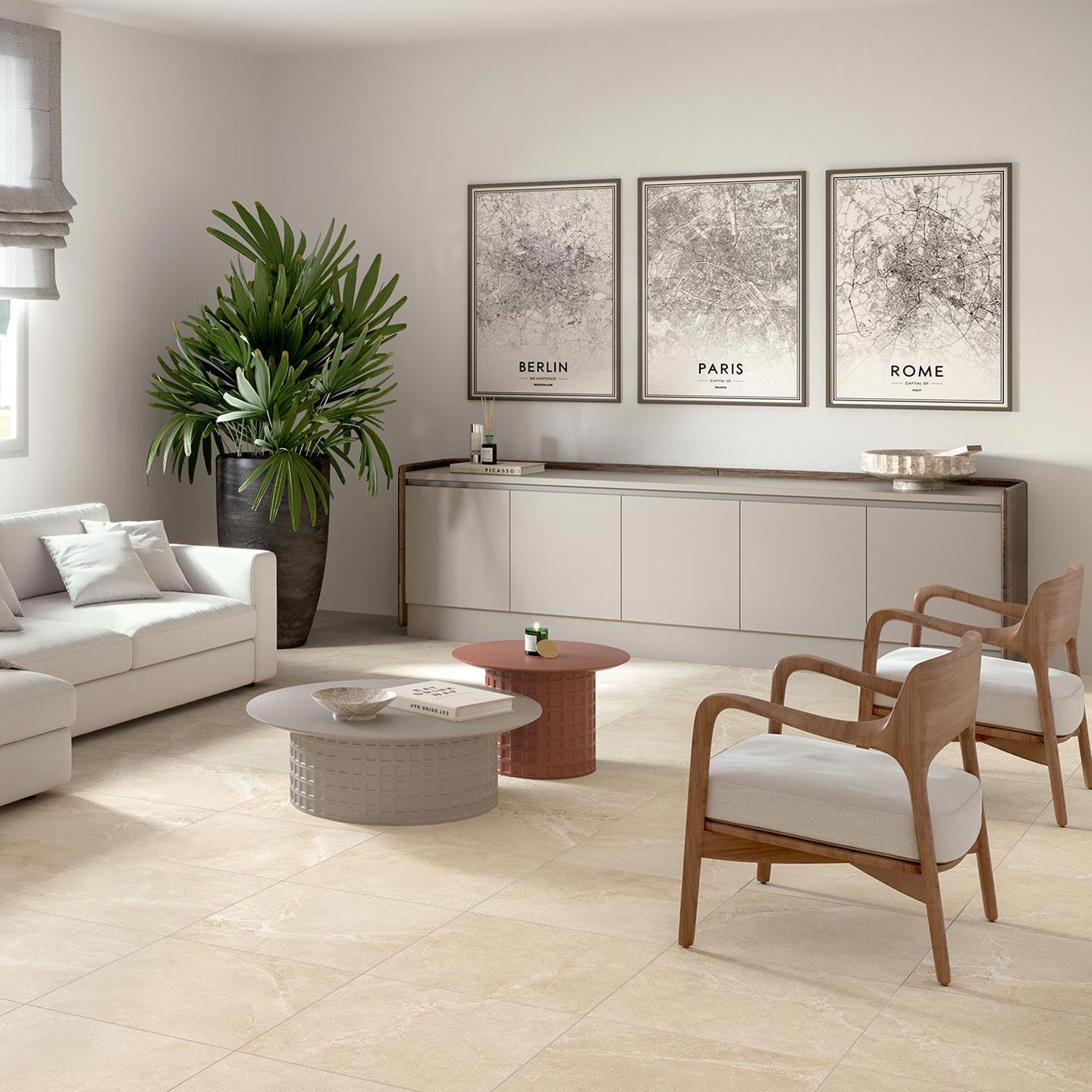 La collezione BLEND, proposta nella calda tonalità Desert e nel formato 60x60 cm, valorizza questo moderno e luminoso ambiente living. Il pavimento in gres porcellanato effetto pietra color sabbia è posato in modo regolare, donando armonia e continuità visiva alla stanza. L'arredamento, caratterizzato da un elegante divano angolare bianco, due poltroncine in legno e tessuto chiaro, tavolini da caffè di design e una grande pianta verde d'appartamento, crea un'atmosfera di sofisticato e accogliente benessere domestico.