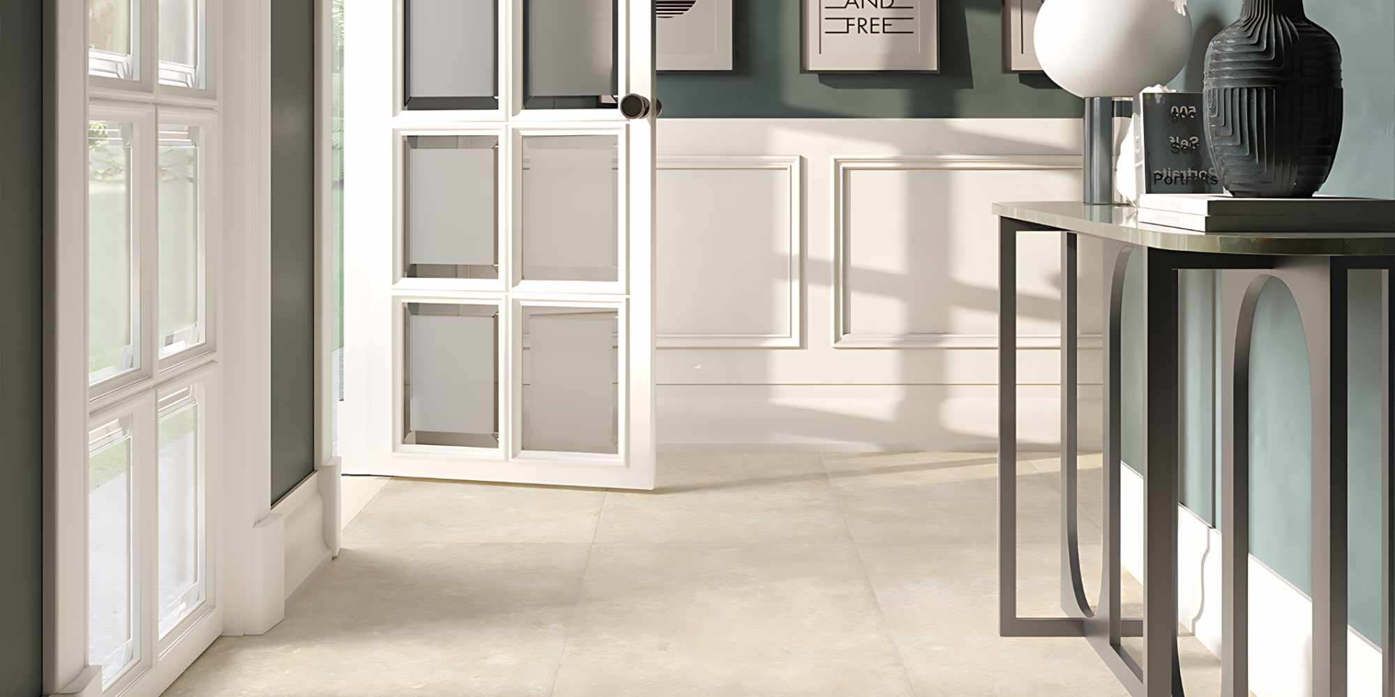 L'immagine mostra un elegante ingresso contemporaneo valorizzato dalla collezione CATHEDRALE nel colore Paris Creme, una superficie ispirata alla pietra calcarea naturale caratterizzata da tonalità beige calde e da una texture morbida e autentica. La posa nel formato 60x120 cm crea un effetto visivo uniforme e raffinato, capace di ampliare lo spazio e di esaltare la luminosità proveniente dalle ampie vetrate laterali.

Le sfumature delicate e le leggere variazioni cromatiche del Paris Creme dialogano armoniosamente con le boiserie bianche, le pareti verde salvia e gli elementi d'arredo dal gusto contemporaneo, creando un ambiente accogliente e sofisticato. La luce naturale mette in risalto la matericità della superficie, conferendo profondità e un realismo che richiama il fascino senza tempo della pietra naturale.